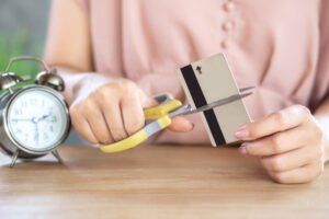 woman cutting credit card to be debt free