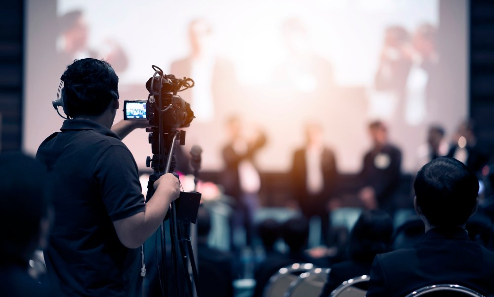 a man standing with a camera shooting a video