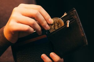 woman putting bitcoin in wallet